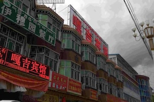A multi-story building with various commercial signs and a balcony.