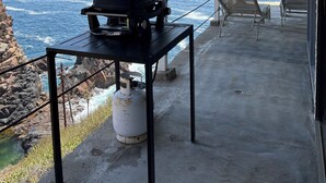 A covered outdoor area with a grill, chairs, and a gas cylinder. - Baja Off the Grid, Luxury Nature Glamping Retreat (Cabo Punta Banda)