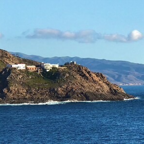 Un edificio costiero con diverse strutture su una scogliera a picco sul mare.