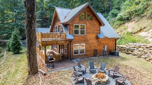 A wooden cabin with a deck, outdoor seating, and a fire pit. - Bearfoot's Nantahala Retreat-Pastoral View - Internet - Pool table - Fire Pit (Bryson City)