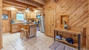 A wooden cabin kitchen with a central island, wooden cabinets, a refrigerator, and a microwave. - Bearfoot's Nantahala Retreat-Pastoral View - Internet - Pool table - Fire Pit (Bryson City)