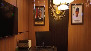 Ein Empfangsschalter mit Computer, gerahmte Bilder an der Wand und eine dekorative Kristallleuchter.