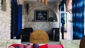 Uma sala de jantar com toalha xadrez vermelha e branca, paredes de pedra e lareira de pedra.