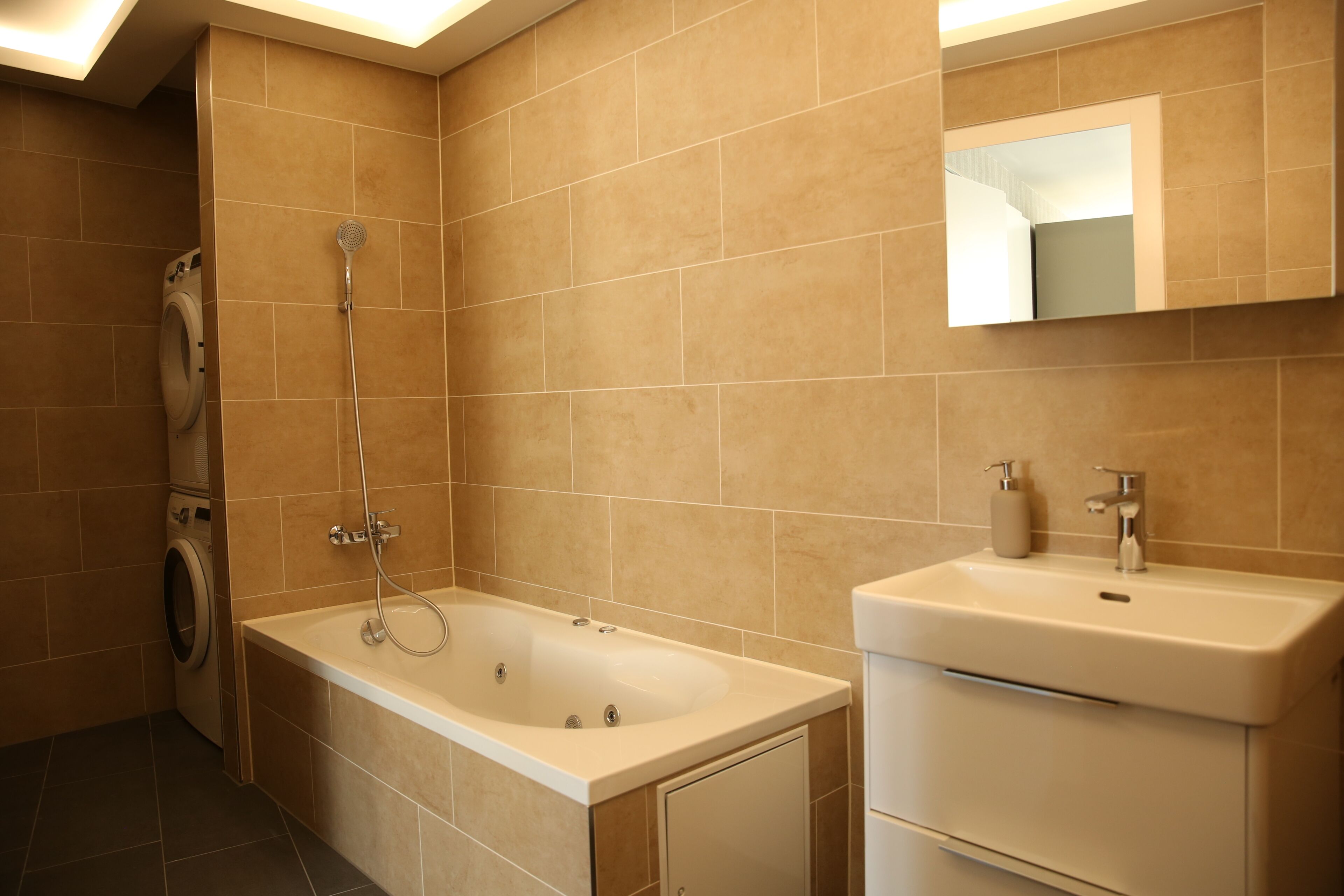 Ein modernes Badezimmer mit einer Badewanne, einem Waschbecken und einem Spiegel.