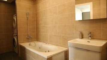Ein modernes Badezimmer mit einer Badewanne, einem Waschbecken und einem Spiegel.