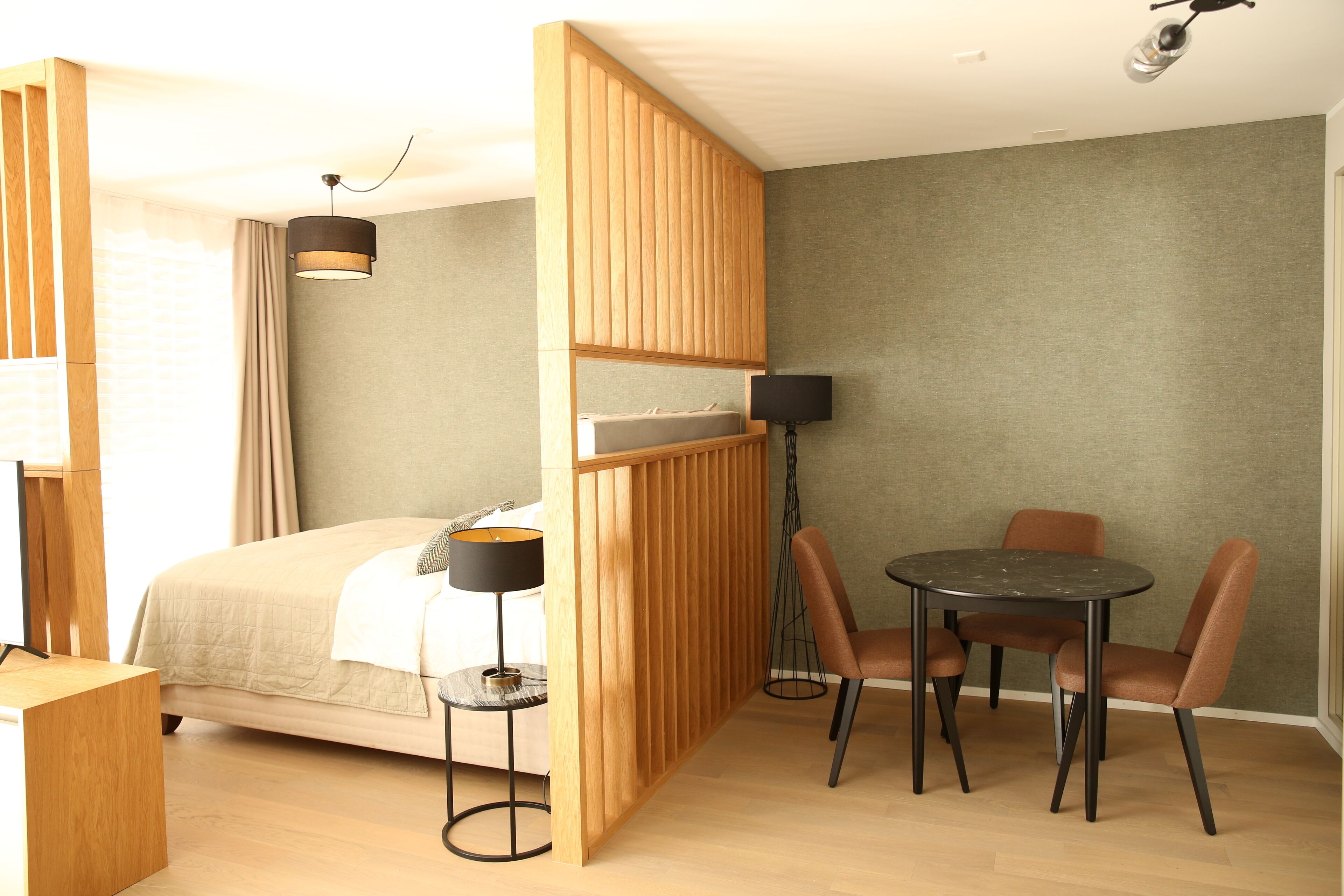 Une chambre à coucher comprenant un lit, une table de chevet, une lampe et une petite table ronde avec des chaises.