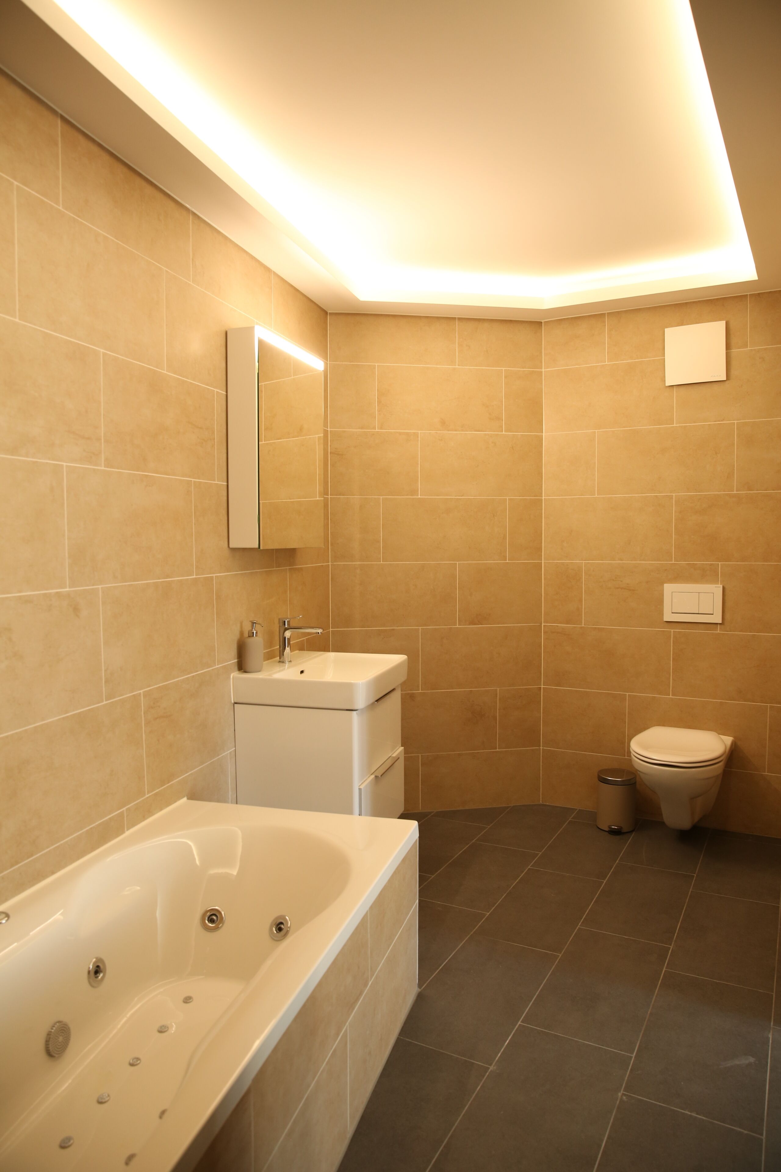 Ein modernes Badezimmer mit Badewanne, Waschbecken und Toilette.