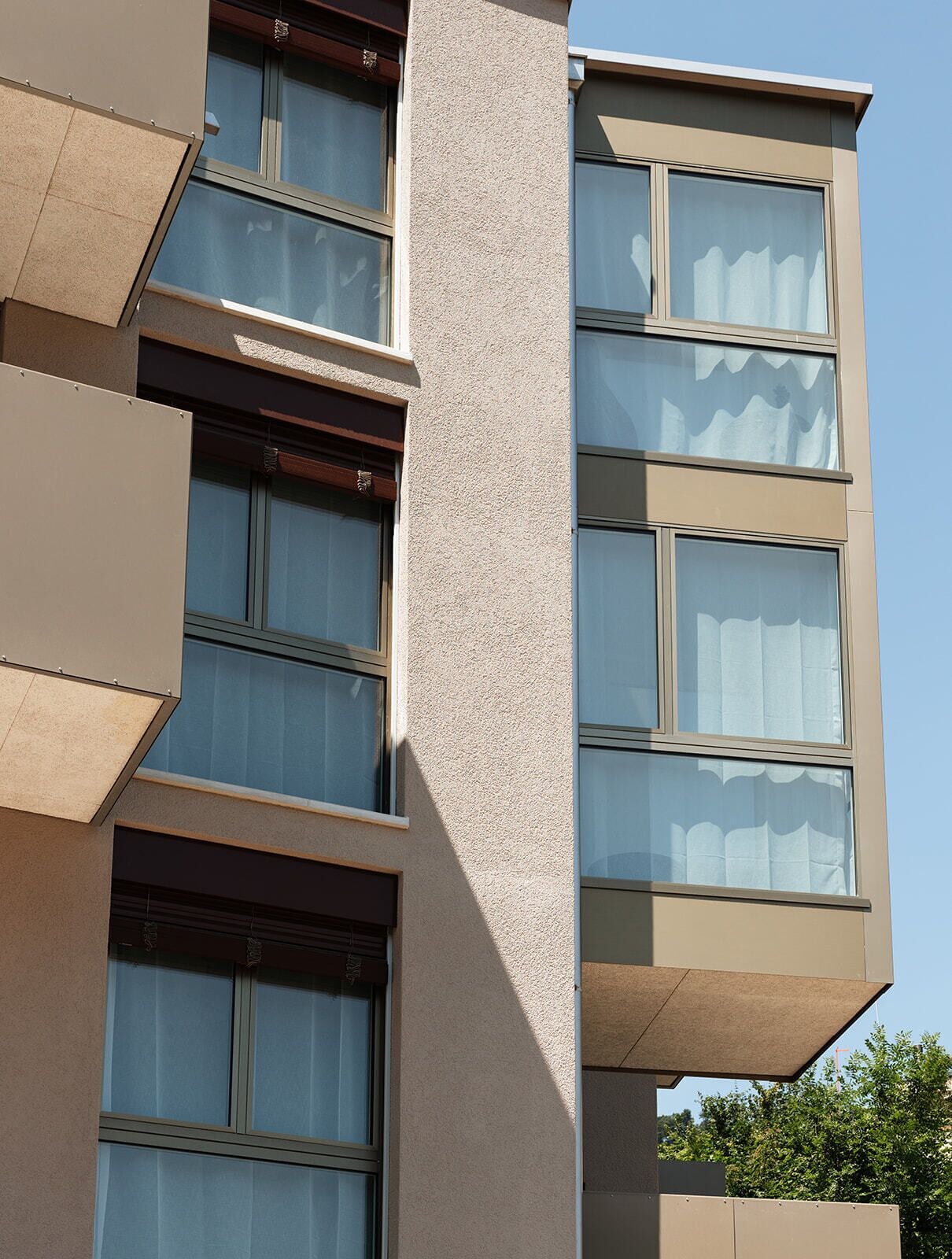 A multi-story building with large windows and a textured facade.