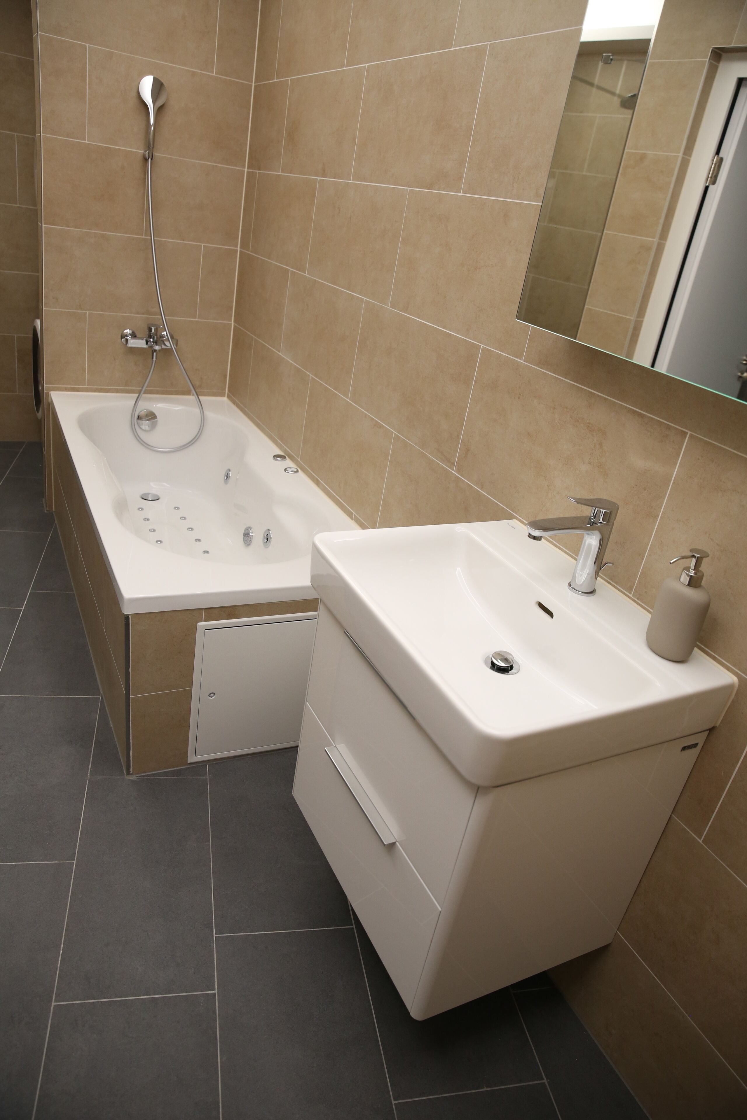 A bathroom with a bathtub, a sink, and a mirror.