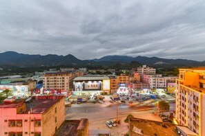 A cityscape with buildings, a parking lot, and mountains in the background. - Boluo Yanting Business Apartment (Boluo)