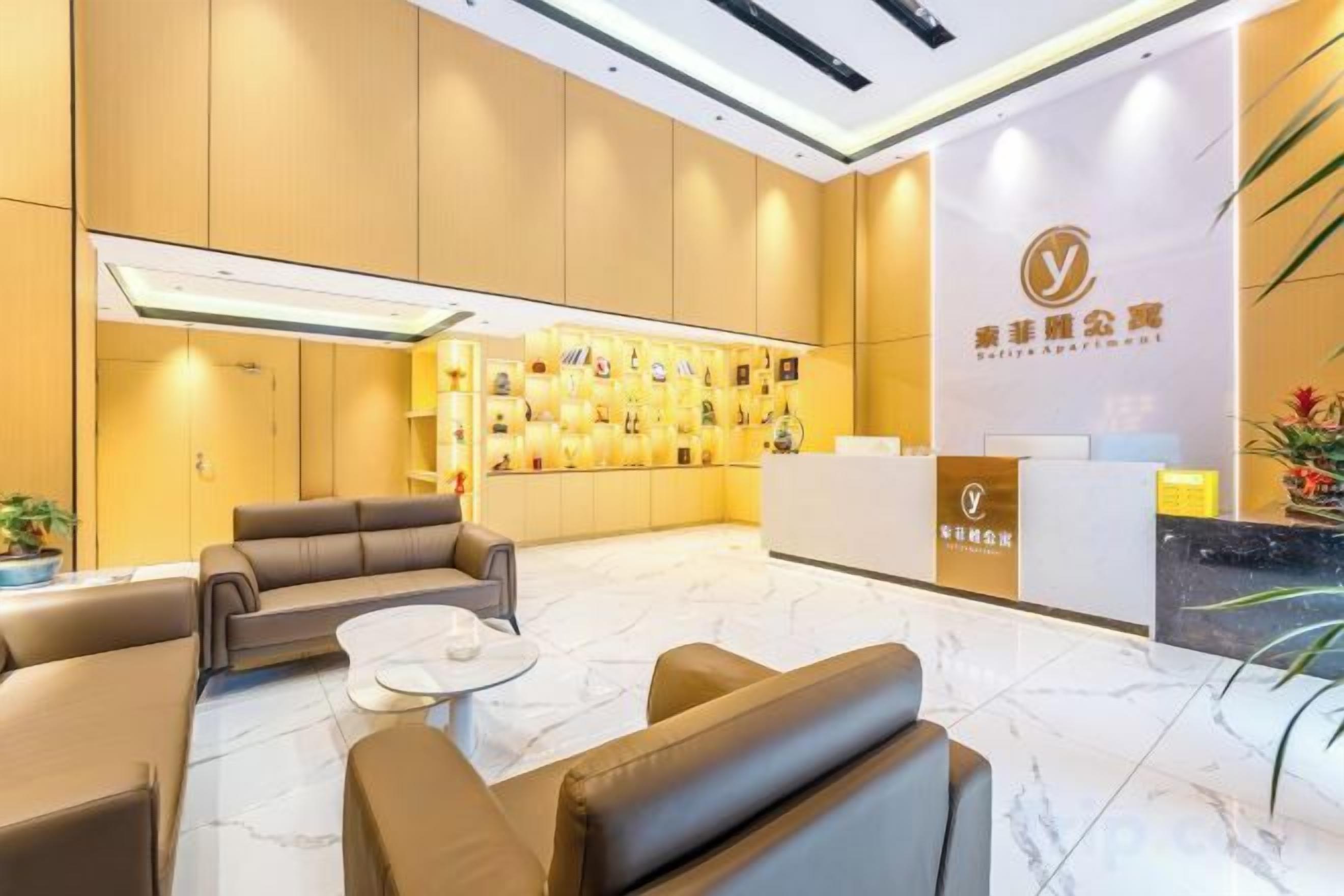 A hotel lobby with a reception desk, seating area, and a wall with framed pictures.