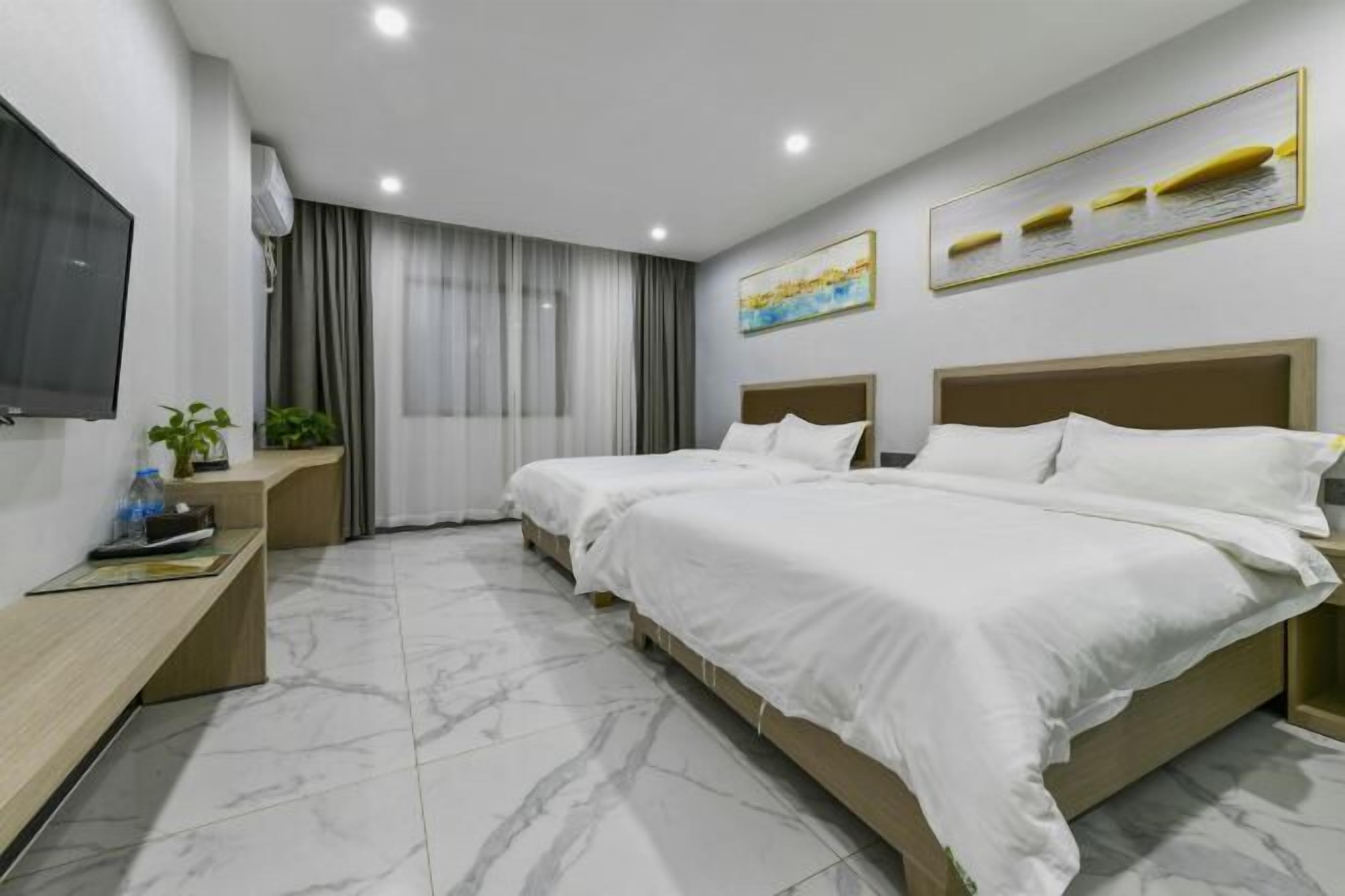 A modern hotel room with two beds, a TV, a desk, and a window with curtains.