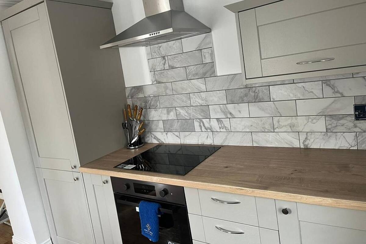 A kitchen with a built-in stove, oven, and a stainless steel range hood.