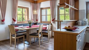 Een moderne keuken met houten kastjes, een ontbijtbalk en een schaal fruit.