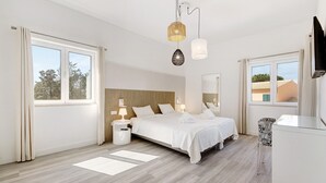 Ein modernes Schlafzimmer mit Bett, Nachttischen, Schreibtisch und Stuhl.