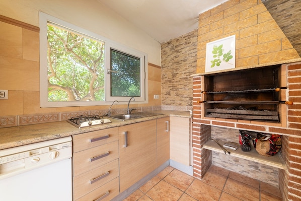 A kitchen with a built-in oven, a window with a view of trees, and a tiled backsplash. - Holiday Home Villa Mansa with Mountain Views, Private Pool and Wi-Fi (Pechina)