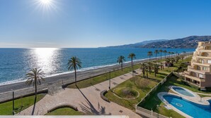 A beachfront hotel with a swimming pool, a promenade, and a view of the sea. - Apartment 'Bonito Apartamento Frente Al Mar' with Sea View, Wi-Fi and Air Conditioning (Salobreña)