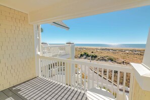 Un balcon avec vue sur la plage et l’océan.
