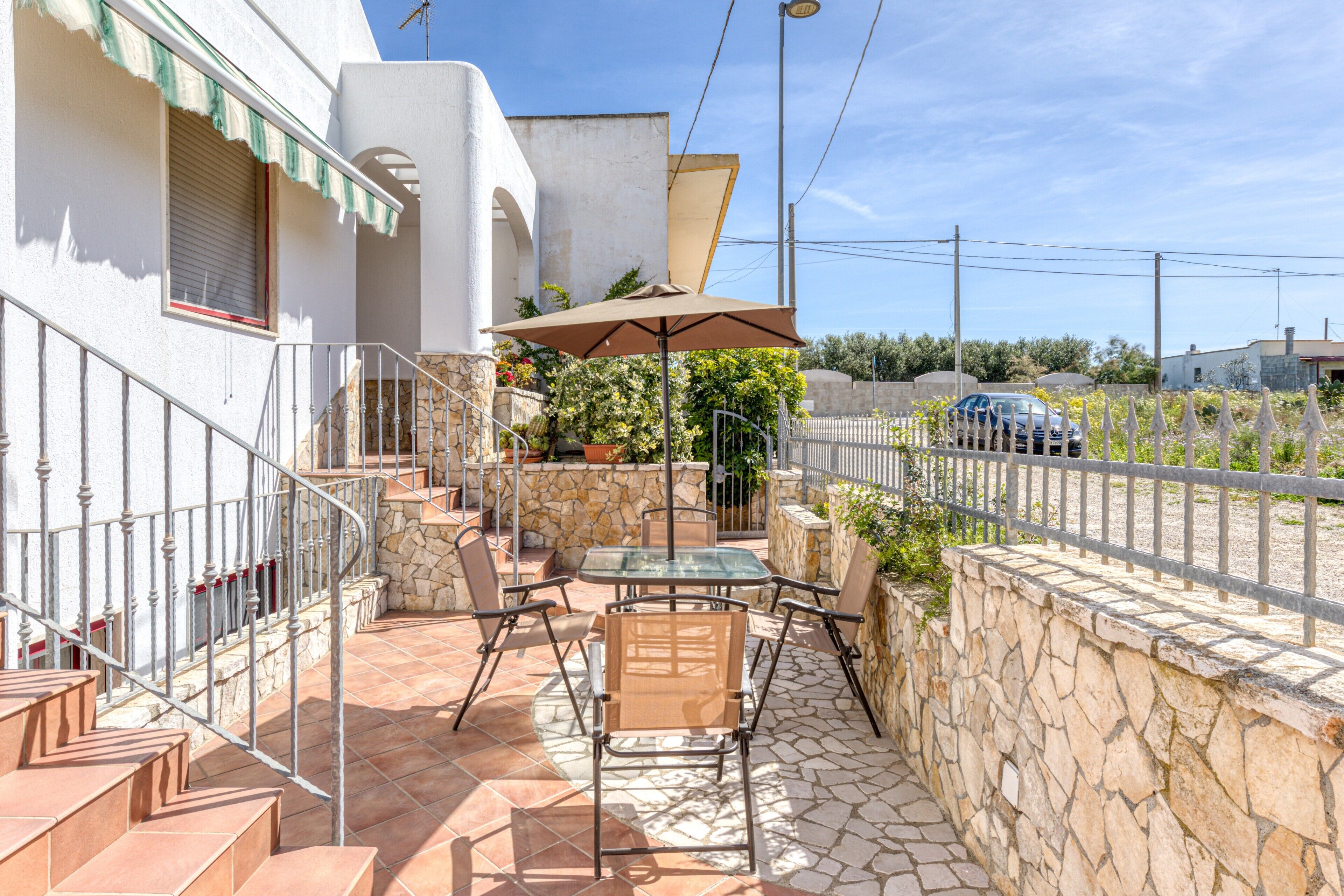 Eine Terrasse mit Gartenmöbeln, einem Tisch und einem Stuhl.