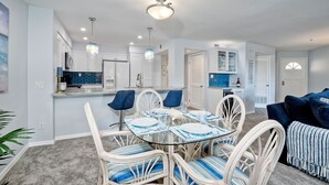 A modern kitchen with white cabinets, a blue backsplash, and pendant lighting. - Ocean View, Pool, Hot Tub, Steps To Pier, Gated (Oceanside)