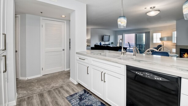 A modern kitchen with white cabinetry, a dishwasher, and a marble countertop. - Ocean View, Pool, Hot Tub, Steps To Pier, Gated (Oceanside)