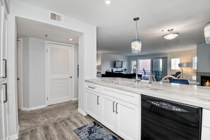 A modern kitchen with white cabinetry, a dishwasher, and a marble countertop. - Ocean View, Pool, Hot Tub, Steps To Pier, Gated (Oceanside)