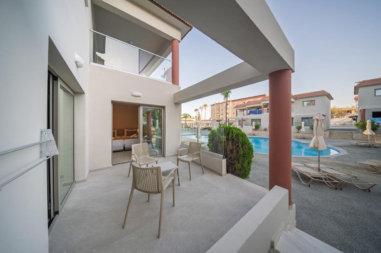 Ein modernes Gebäude mit Balkon, Pool und Sitzgelegenheiten im Freien.