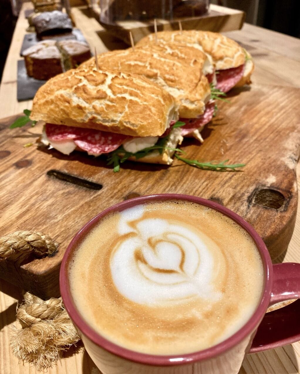 A sandwich and a cup of coffee on a wooden table.
