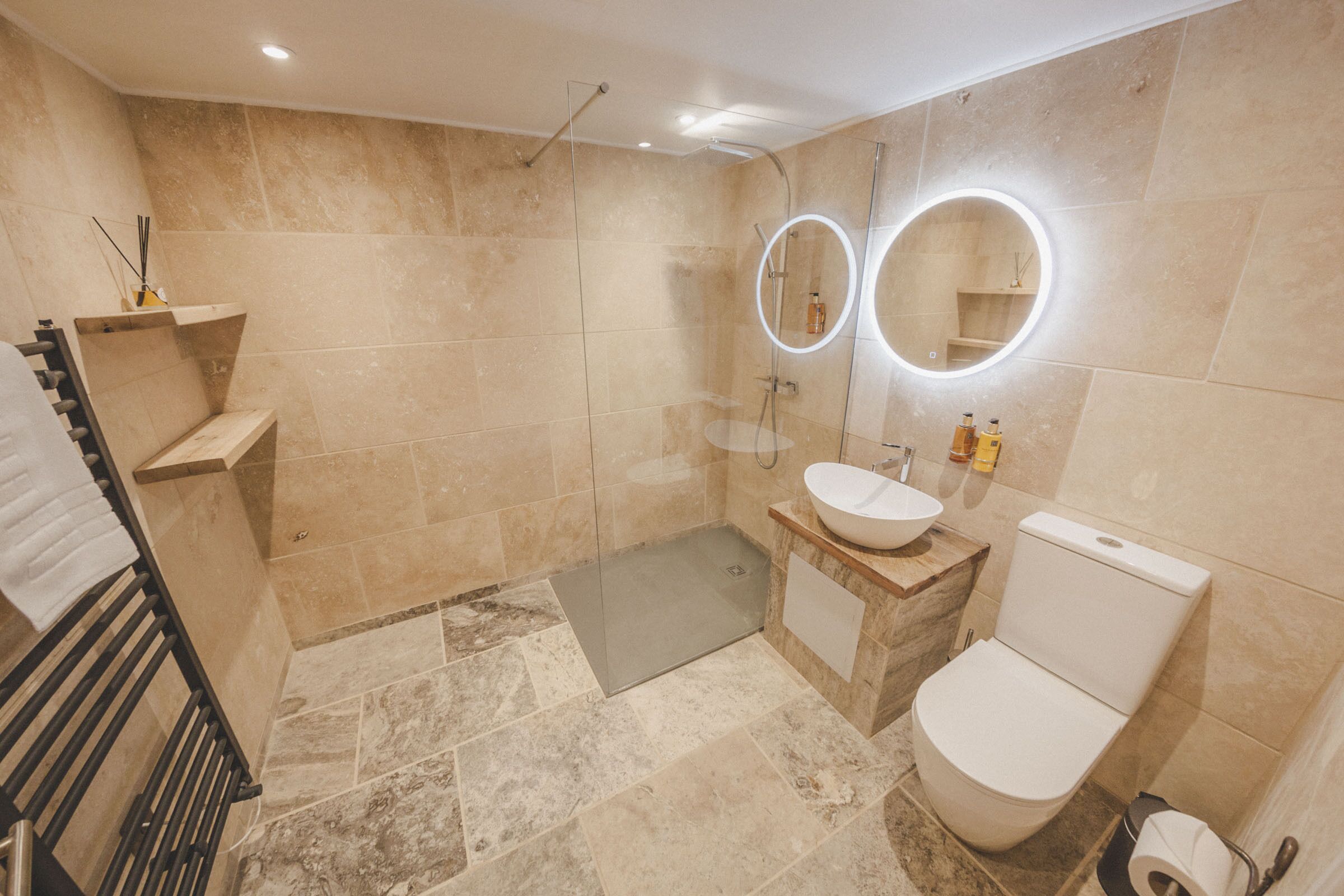 A modern bathroom with a glass shower enclosure, a vanity with a sink and mirror, and a toilet.