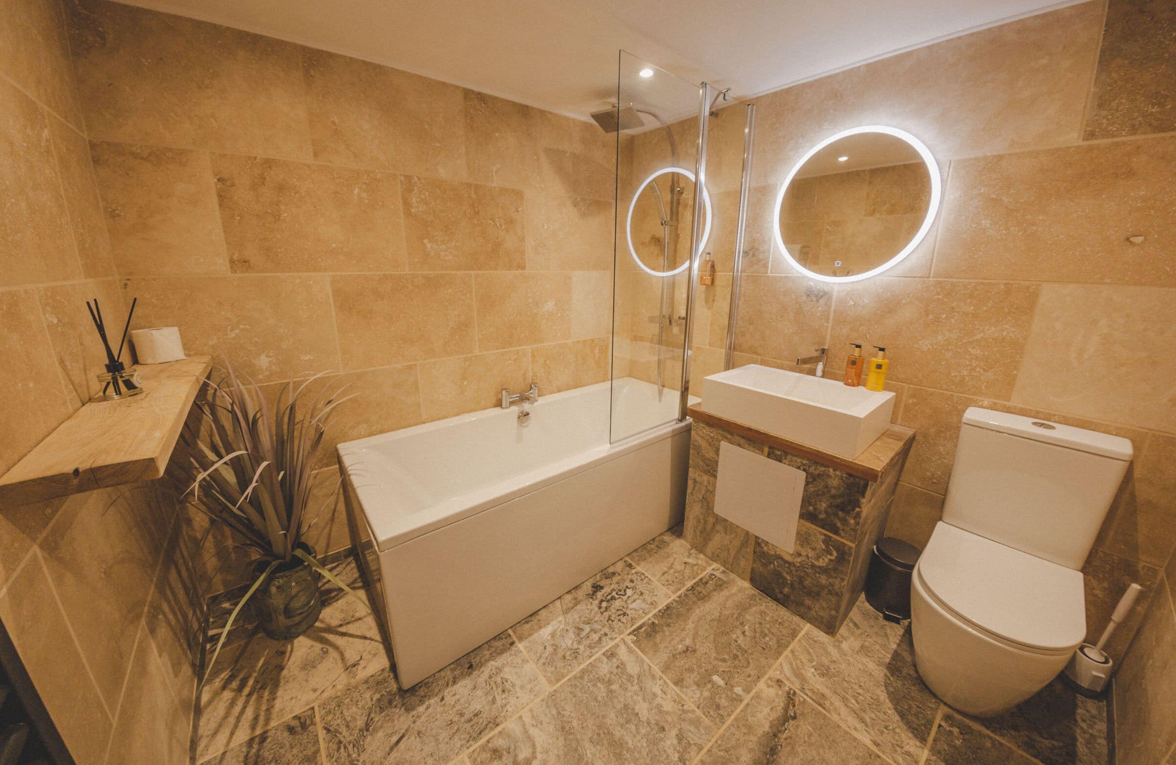 Een moderne badkamer met een bad, een wastafel en een toilet.