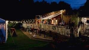 An outdoor dining area with string lights, tables, and chairs. - Trading Boundaries (Uckfield)