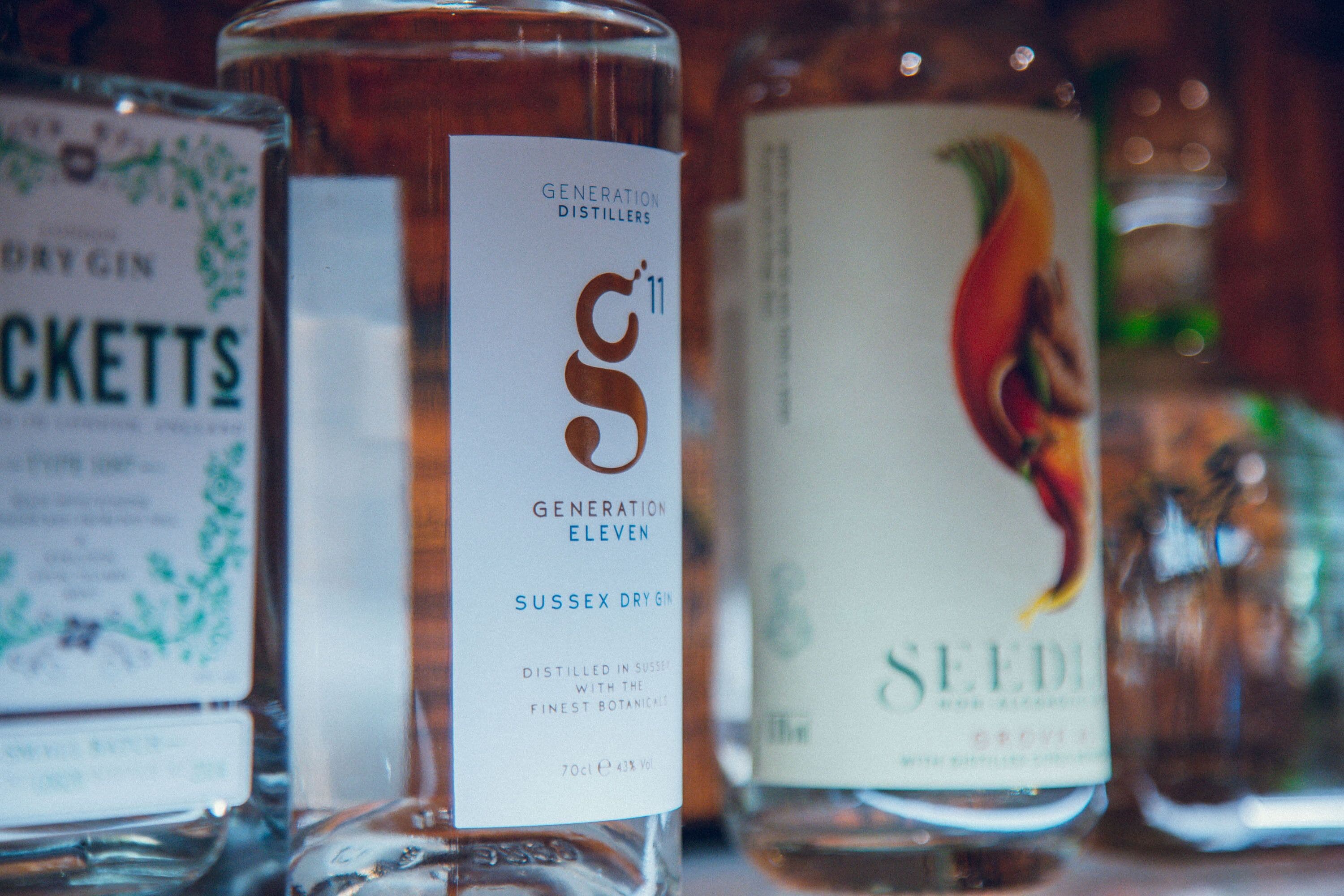 Primer plano de tres botellas de ginebra con etiquetas.