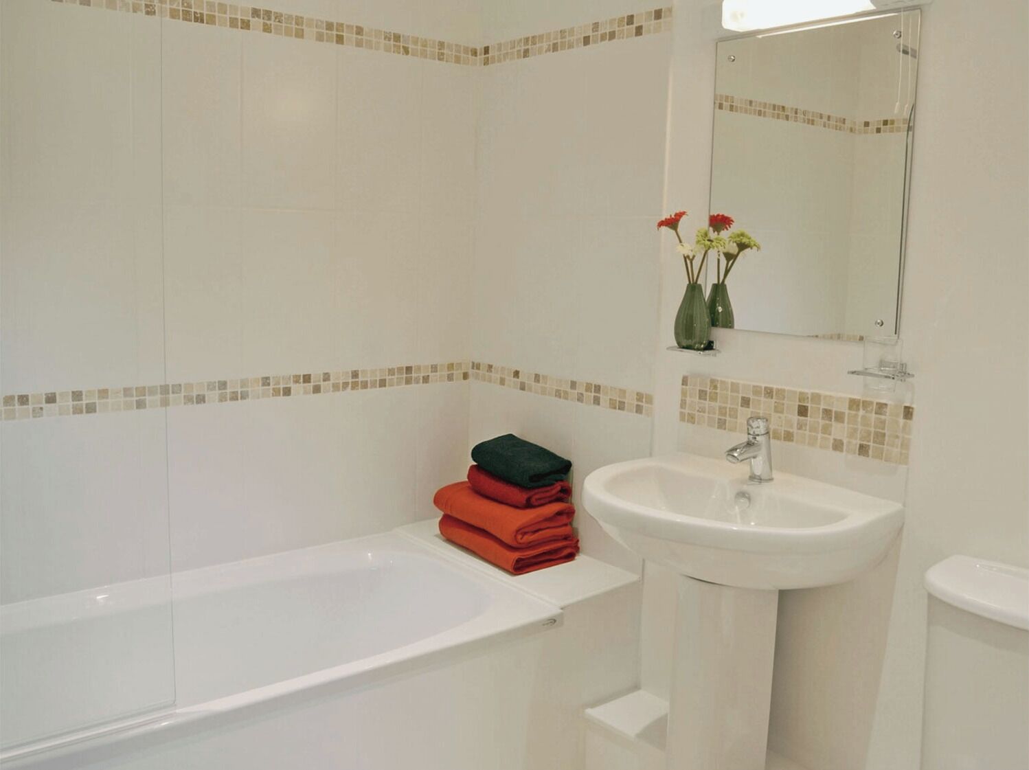 Une salle de bain avec une baignoire, un lavabo et un miroir.