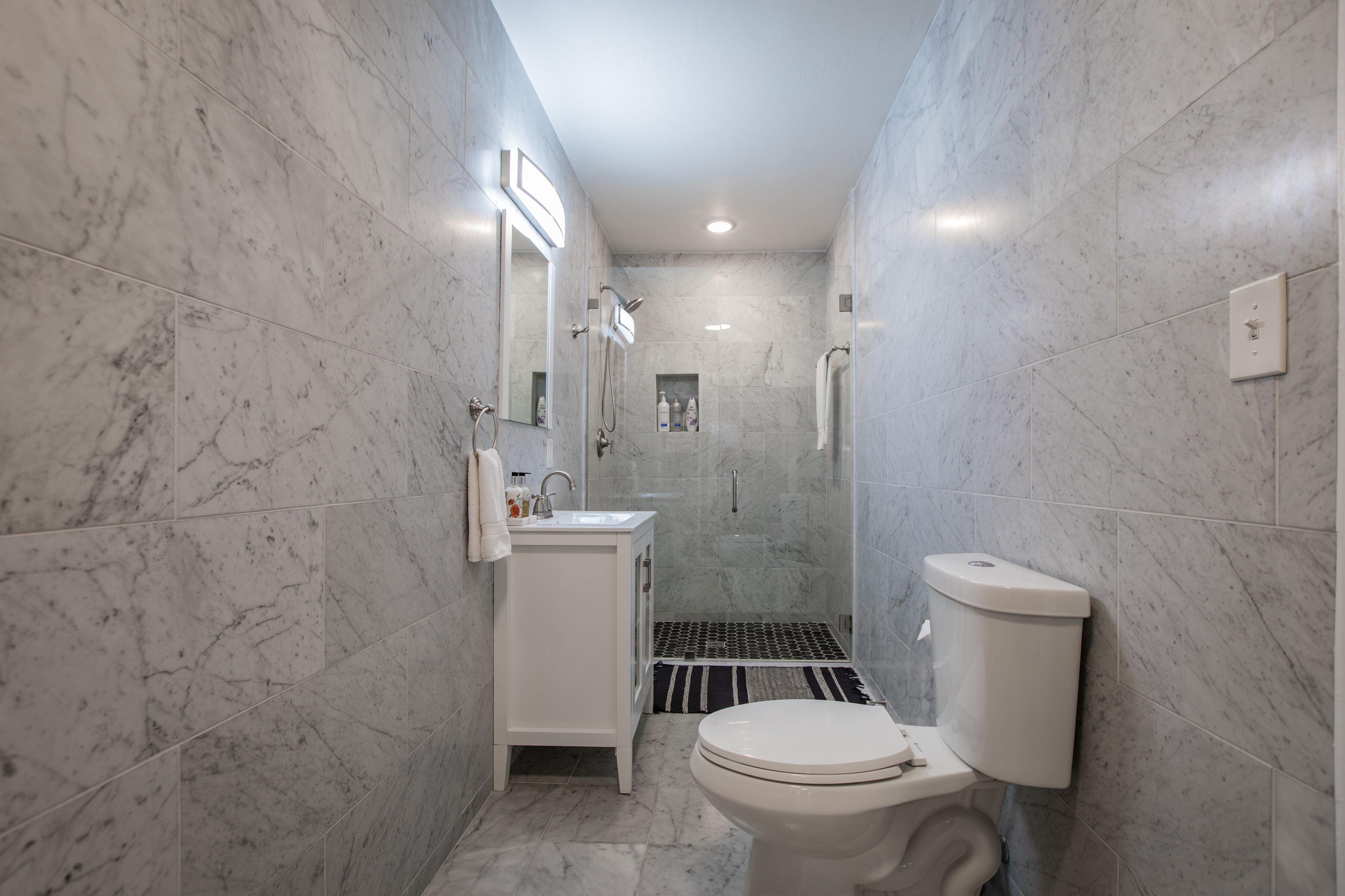 A bathroom with a toilet, sink, and shower.