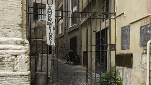 En smal gränd med kullerstenar, en grind av metall och en skylt med texten ”Bodefiori”.