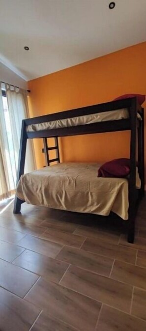 Cozy retreat with a bunk bed, featuring a window with curtains.