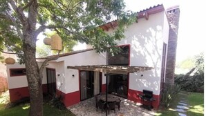 A patio area with a stone floor, a wooden table, and a rustic pot. - Mid Town Tapalpa 2 (Tapalpa)