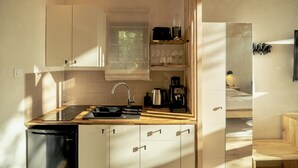 A compact kitchen with a sink, stove, and coffee maker.
