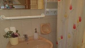 A bathroom with a beige sink, a small step stool, a soap dispenser, and a shower curtain with a floral pattern. - Georgia Old Town Apartments - Double Room (N.5), Georgia Old Town Apartments Rhodes (Ρόδος,)