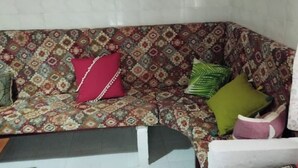 A patterned sofa with multiple cushions in various colors. - La Casa del Río, natural pool 5 min by car (Villacarrillo)