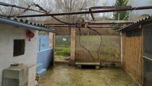 A rustic outdoor area with a concrete bench, a metal fence, and a wooden structure. - La Casa del Río, natural pool 5 min by car (Villacarrillo)