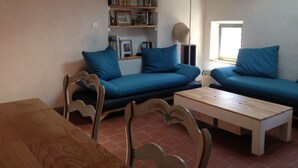 A living room with a blue sofa, a wooden coffee table, and a bookshelf. - Apartment @typique (Vieux Port) (La Ciotat)