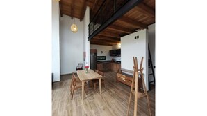 Un'ampia sala da pranzo con un tavolo e sedie in legno, una panca e un lampadario.