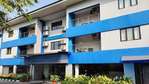 A hotel with a blue and white facade, air conditioning units, and a sign reading "Riviera Hotel". - Riviera Suites (Lagos)