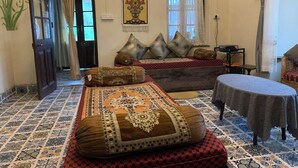 Una habitación tradicional con cama, una mesa y un tapiz decorativo.