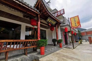 A traditional building with a wooden balcony and red lanterns.