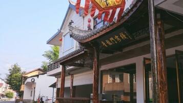 A traditional building with a balcony and a signboard.