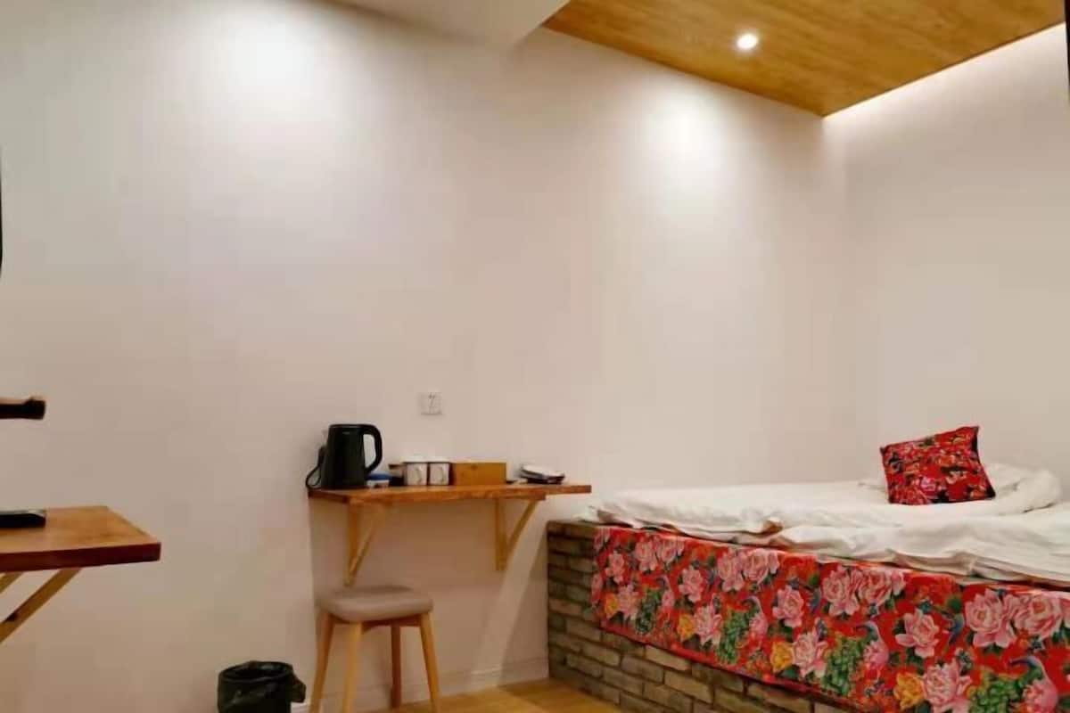 Un petit logement composé d’une seule pièce, comprenant un lit, un bureau et une chaise.