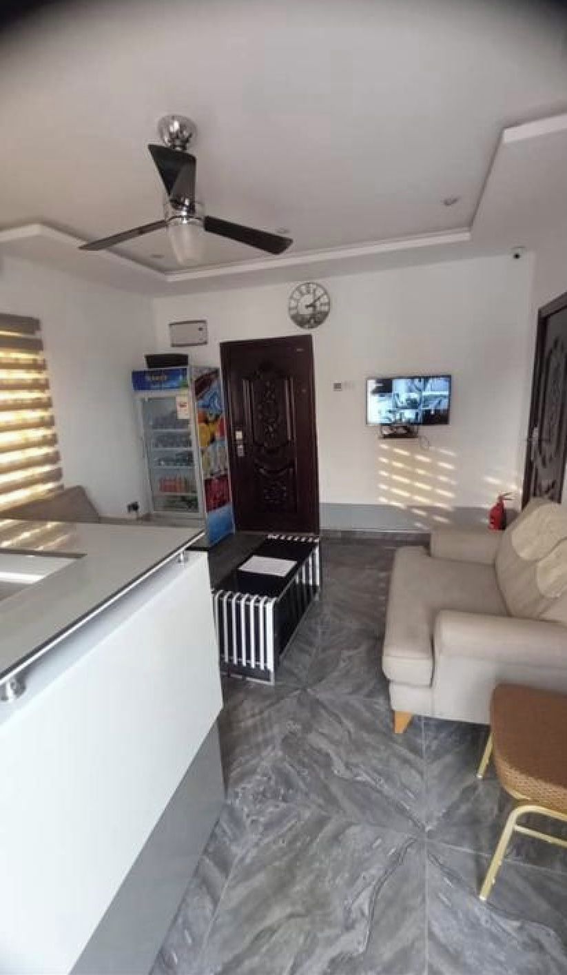 Una sala moderna con un sofá, una televisión y un ventilador de techo.