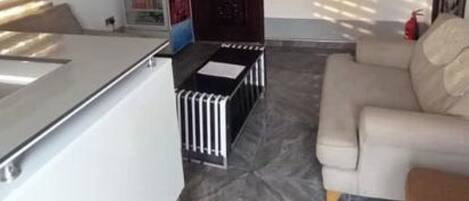 Una sala moderna con un sofá, una televisión y un ventilador de techo.